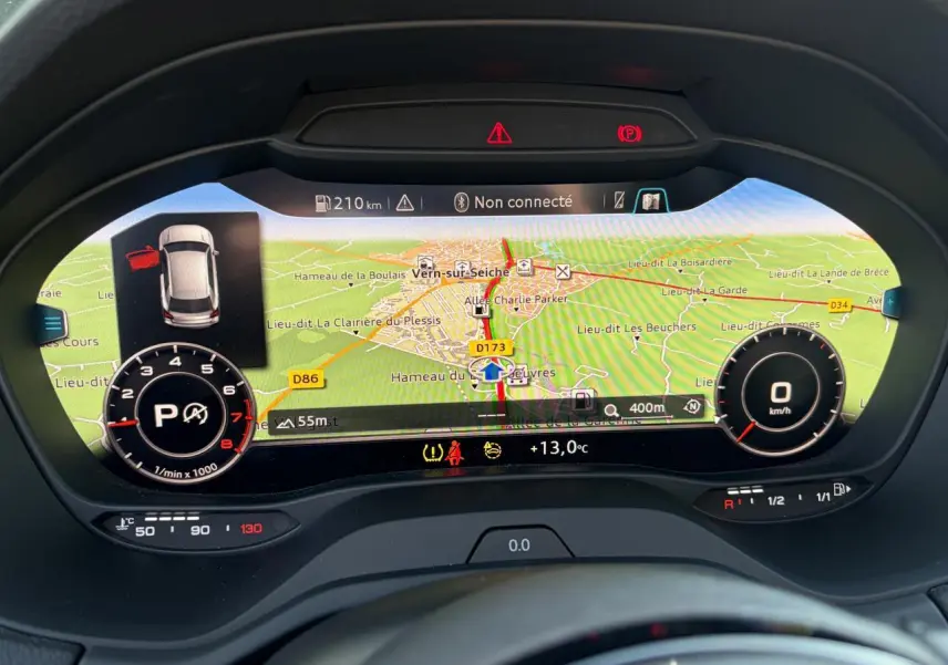 Affichage numérique du tableau de bord de l'Audi Q2 35 TFSI 2024 avec navigation et indicateurs de vitesse et régime moteur.