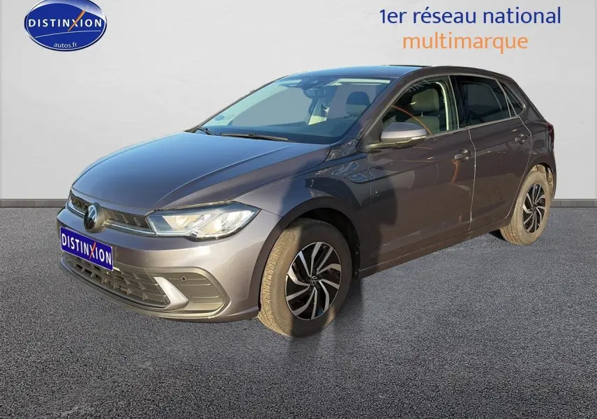 Volkswagen Polo gris vue 3/4 avant droit avec jantes alu et phares LED allumés sur fond clair.