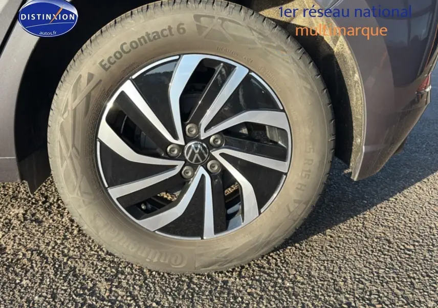 Gros plan sur la roue avant droite d'une Volkswagen Polo gris 2025 avec jante alu bicolore design moderne.