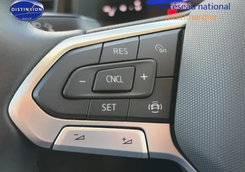 Gros plan sur les commandes du volant multifonction de la Volkswagen Polo gris 2025, avec boutons de régulateur de vitesse.