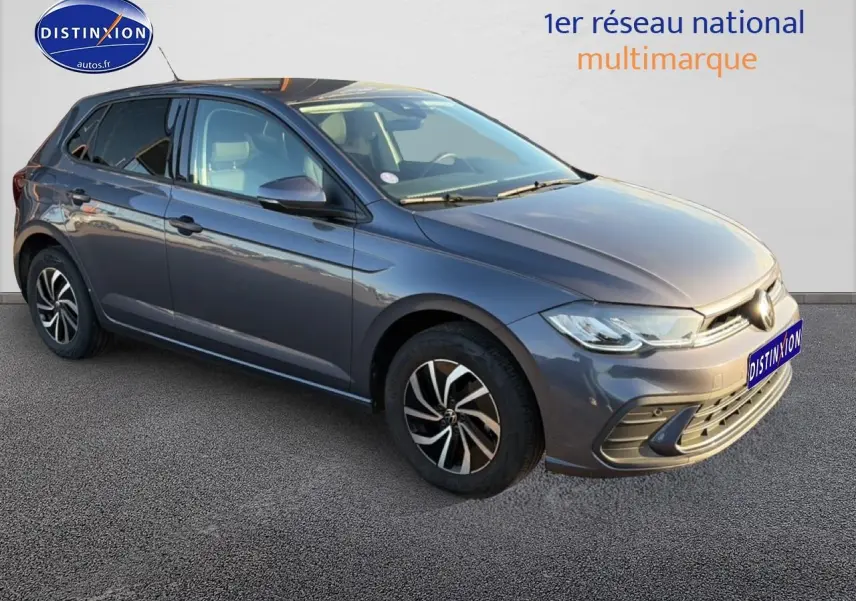 Volkswagen Polo gris vue 3/4 avant droit, avec jantes alu et phares LED allumés.
