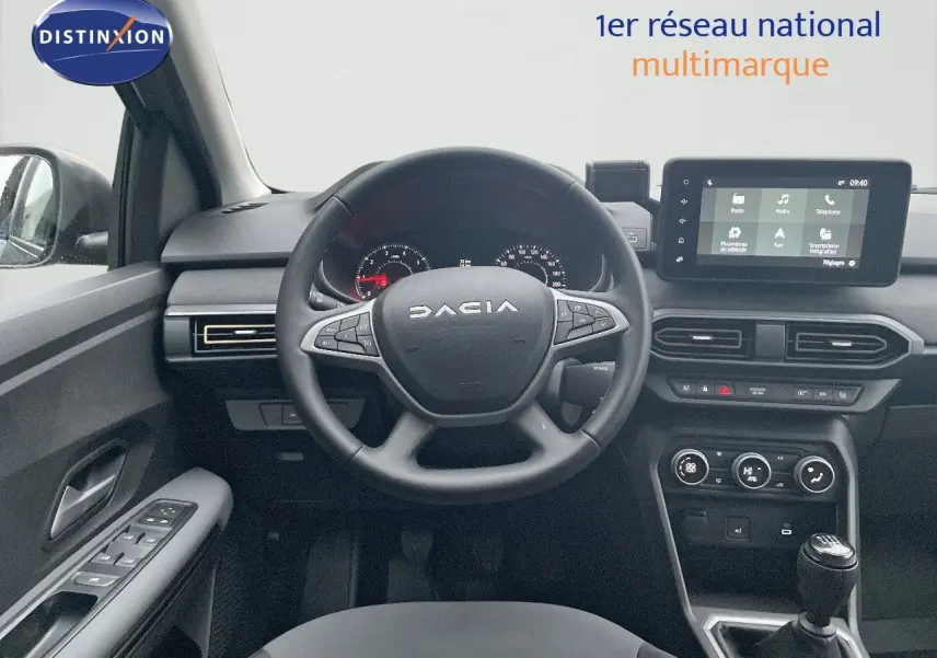 Intérieur du Dacia Jogger 2026 en vue frontale, volant multifonction, écran tactile et levier de vitesses manuel visibles.