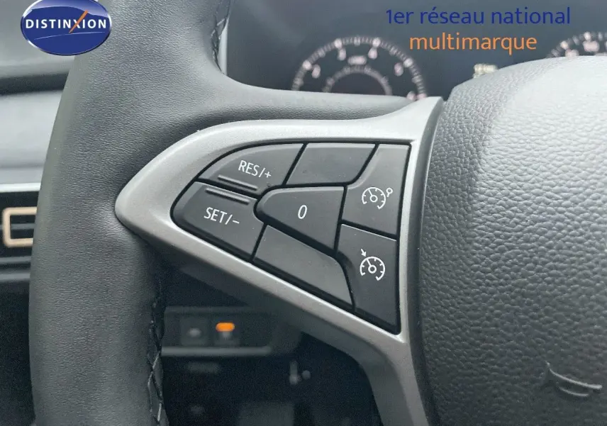 Gros plan sur les commandes de régulateur de vitesse au volant cuir d’une Dacia Jogger gris schiste métal.