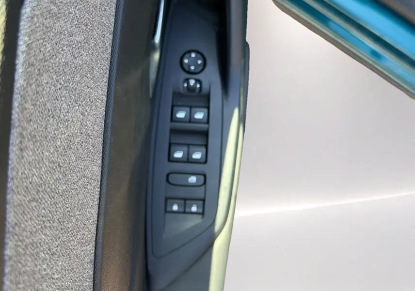 Panneau de commandes des vitres et rétroviseurs côté conducteur de la Peugeot 408 Hybrid 145 allure bleu 2025.