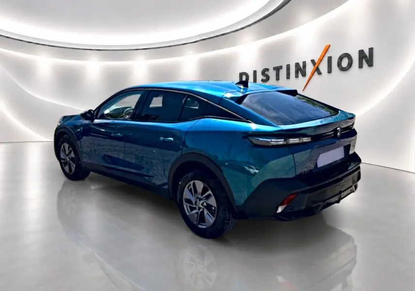 Vue 3/4 arrière droite d'une Peugeot 408 Hybrid 145 allure e-dcs6 bleu dans un showroom lumineux avec logo Distinxion.