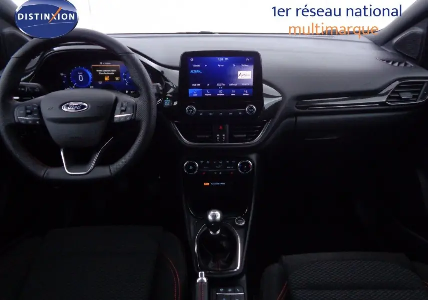 Vue intérieure du tableau de bord et volant d'une Ford Puma gris Solar Metal avec boîte manuelle, affichage numérique et écran tactile central.