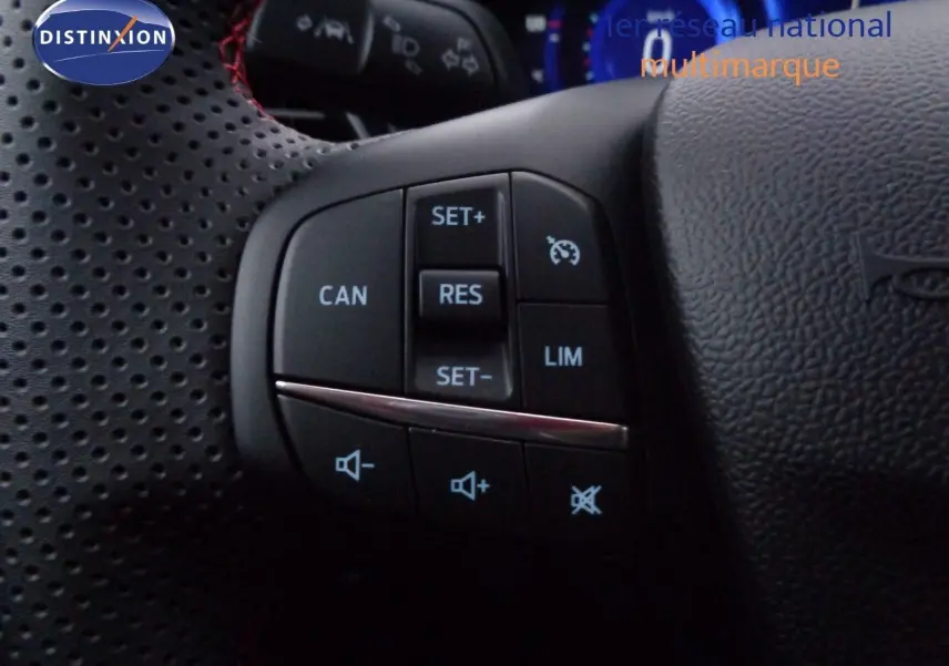 Gros plan sur les commandes du volant en cuir perforé noir du Ford Puma 2022, boutons de régulateur de vitesse et volume sonore.