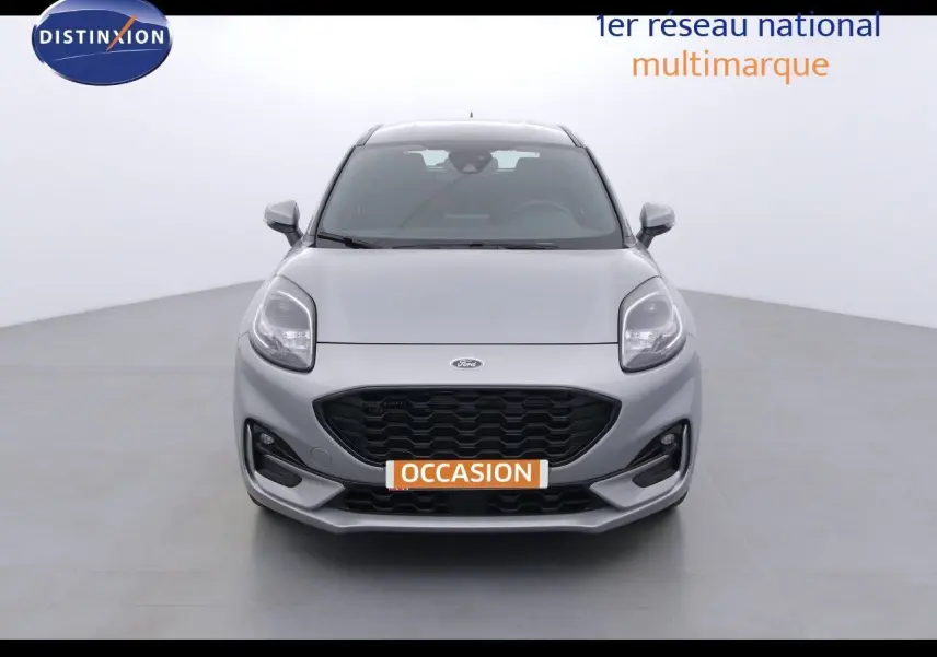 Vue frontale d'une Ford Puma 1.0 EcoBoost hybride gris solar metal avec calandre noire et phares LED allumés.