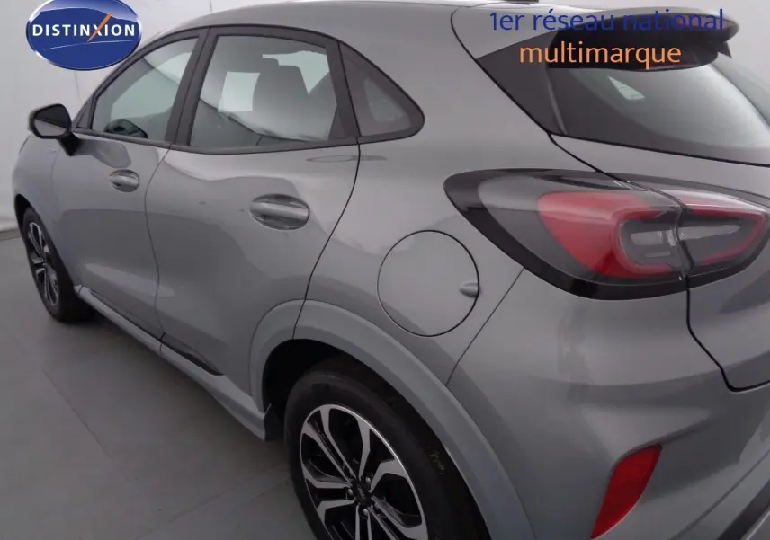 Vue 3/4 arrière côté gauche d'un Ford Puma gris Solar Metal avec feux arrière LED et jantes alliage noires.