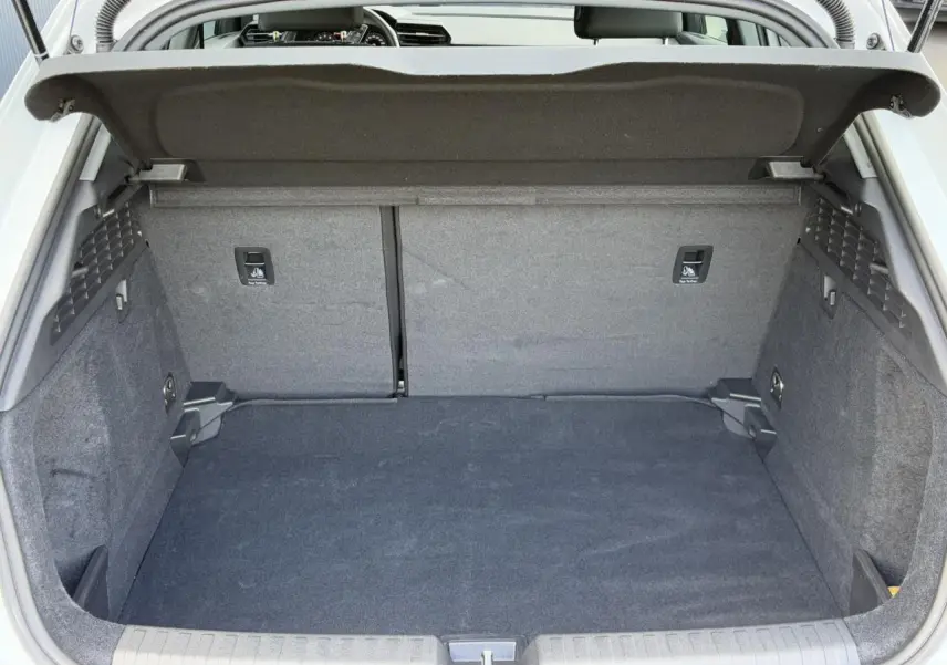 Coffre ouvert vu de l'arrière d'une Audi A3 Sportback blanche Arkona, espace de chargement propre et spacieux.