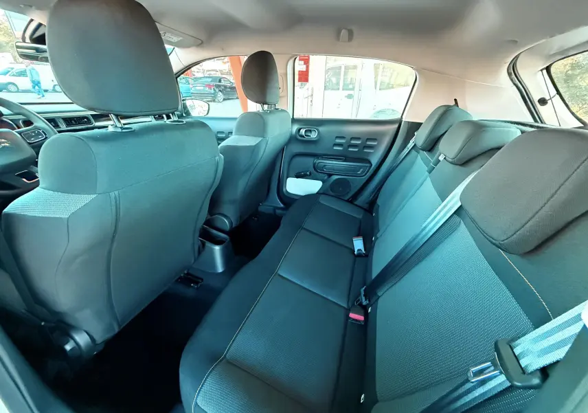 Vue intérieure arrière de la Citroën C3 2021 montrant les sièges arrière en tissu gris noir et les appuie-têtes.
