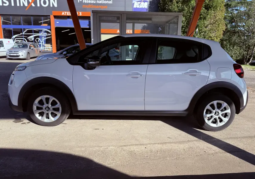 Profil côté gauche d'une Citroën C3 blanche de 2021, avec jantes argentées et poignées de porte assorties.