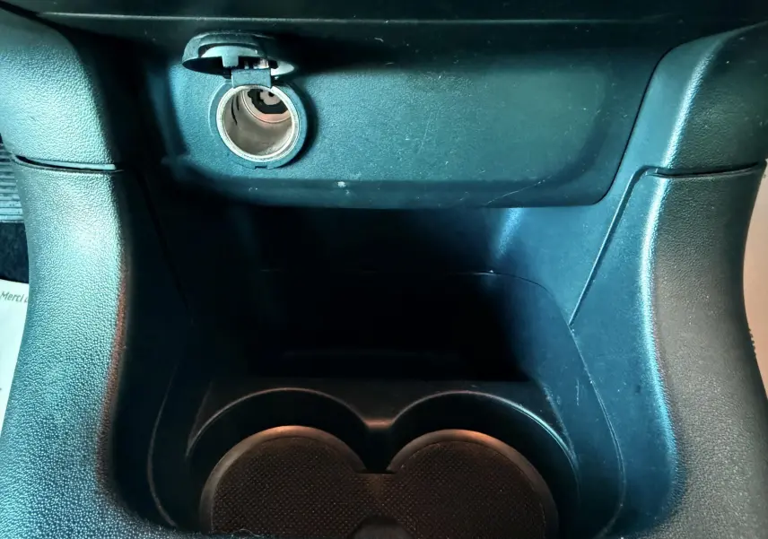 Prise allume-cigare et porte-gobelets noirs en plastique dans l'habitacle d'une Citroën C3 2021.