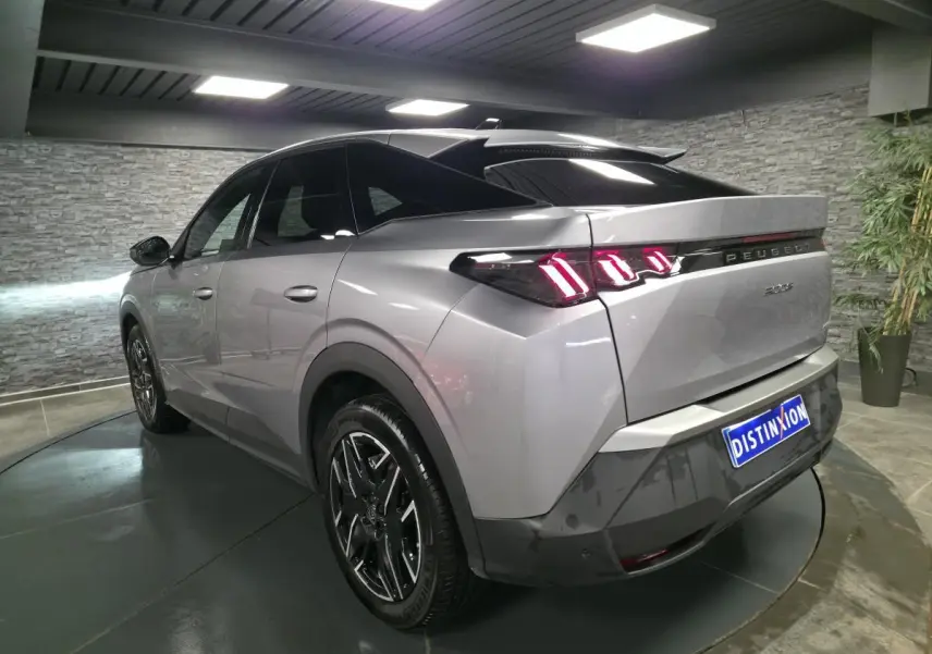 Vue 3/4 arrière droite du Peugeot 3008 gris métallisé avec feux arrière LED en forme de griffes et jantes alliage noires.