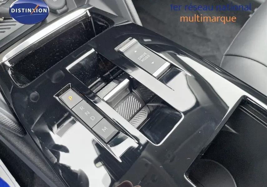 Gros plan sur la console centrale noire brillante avec sélecteur de boîte auto et bouton Drive Mode dans une Citroën C4 blanche.