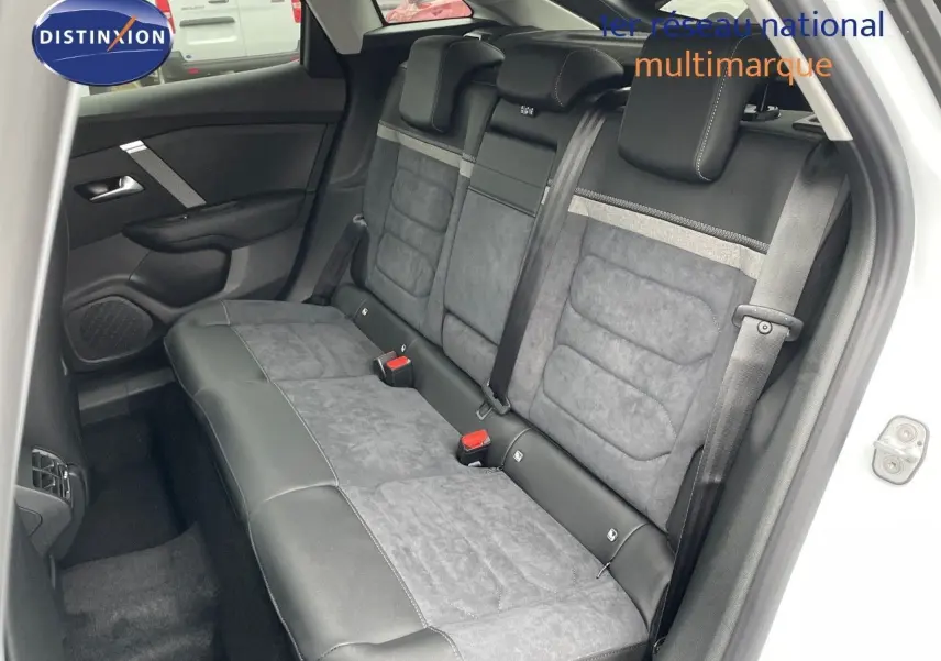 Vue intérieure côté gauche des sièges arrière en cuir noir et alcantara gris d'une Citroën C4 blanche métallisée 2024.