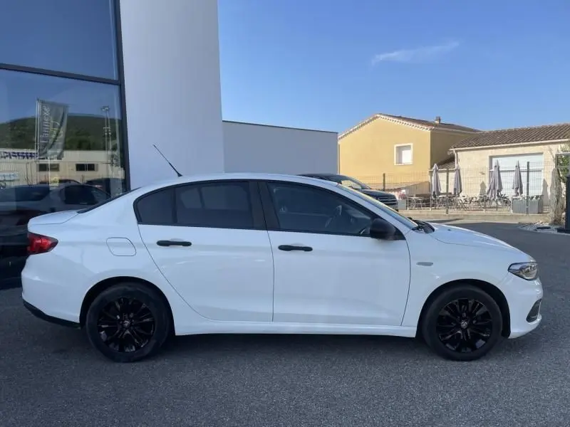 Profil côté gauche d'une FIAT TIPO 1.4 Street blanche de 2019 avec jantes noires et vitres teintées.