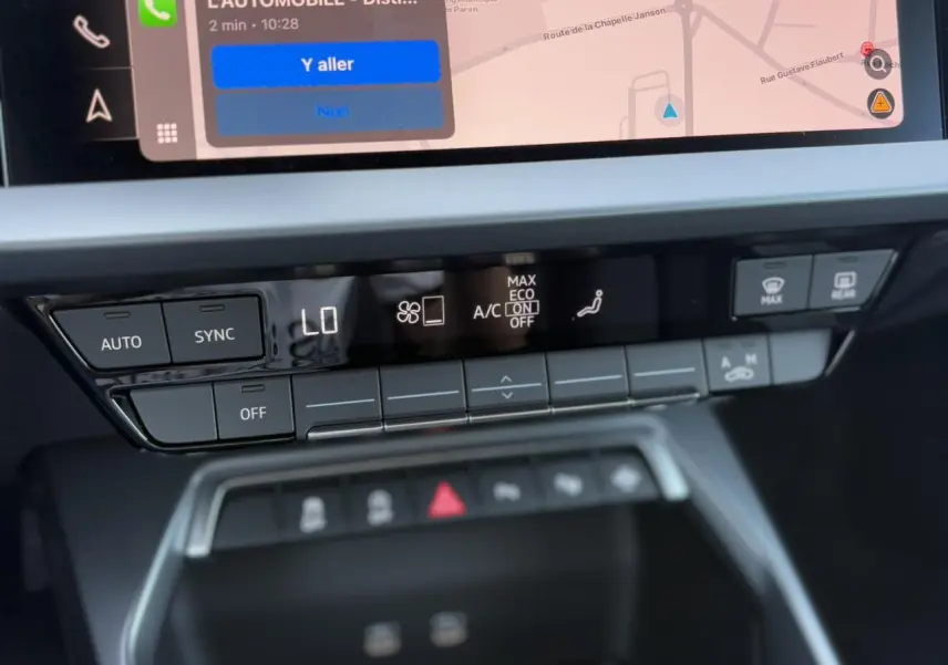Panneau de commande de climatisation et écran tactile du système Apple Car Play dans l'Audi A3 Sportback 2024 blanc Arkona.