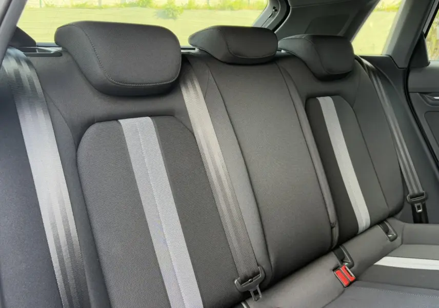 Banquette arrière en tissu gris avec bandes claires et ceintures de sécurité dans une Audi A3 Sportback 2024.