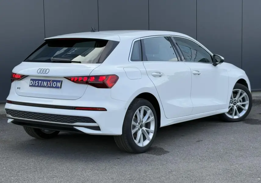 Audi A3 Sportback blanc Arkona vue 3/4 arrière droit, feux arrière LED et jantes alliage 17 pouces visibles.