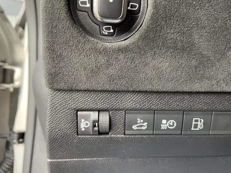 Détail des commandes côté gauche du tableau de bord d'une DS4 gris 2023 hybride rechargeable, avec réglage phares et fonctions véhicule.