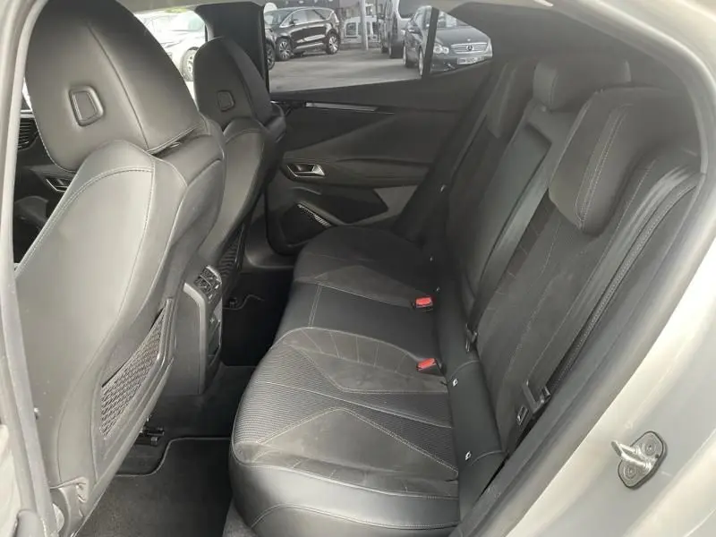 Vue intérieure côté droit des sièges arrière en cuir noir du DS4 Hybride E-Tense 225 gris, avec finitions modernes et ceintures visibles.