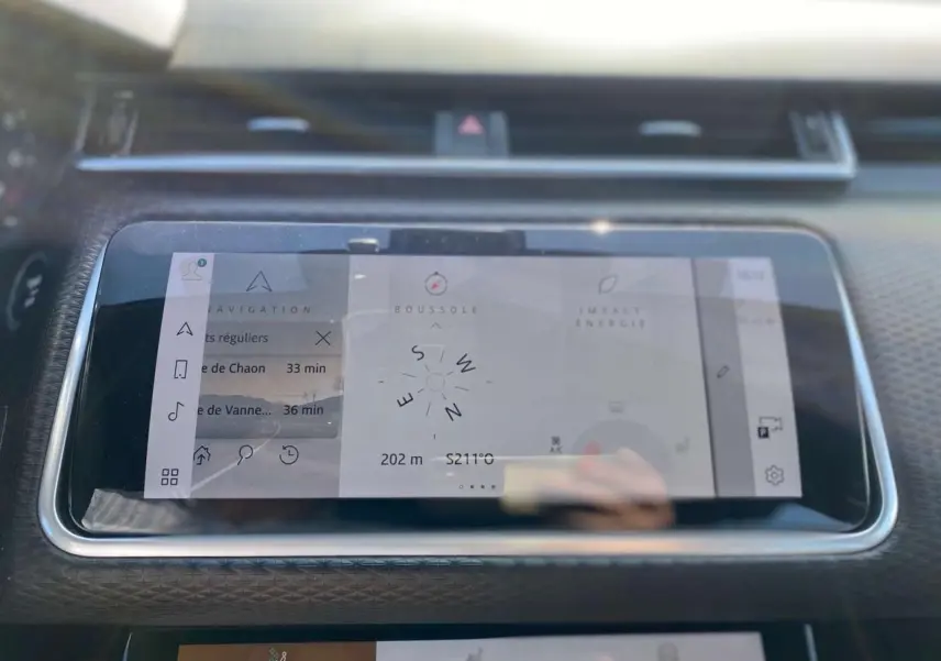 Écran tactile central du Range Rover Velar 2022 affichant navigation et boussole, avec tableau de bord noir texturé.