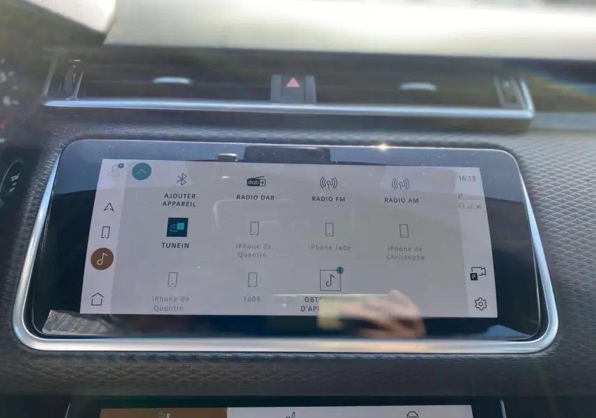 Écran tactile central du Range Rover Velar 2022 en gros plan, affichant les options radio et connectivité Bluetooth.