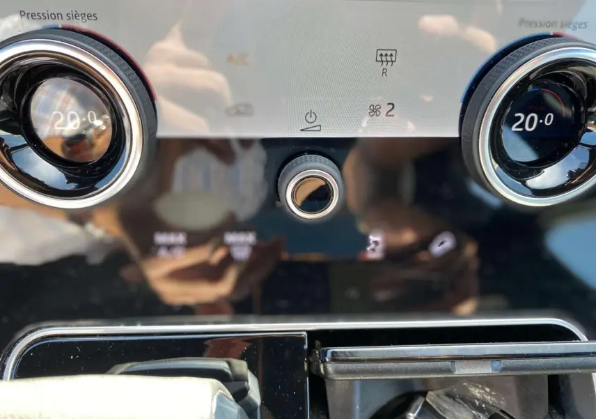 Détail du tableau de bord du Range Rover Velar 2022 montrant les commandes de climatisation et les aérateurs ronds chromés.
