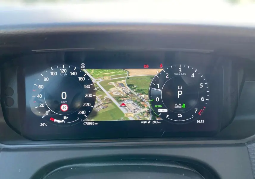 Tableau de bord numérique du Range Rover Velar gris, affichant vitesse, navigation et indicateurs hybrides.