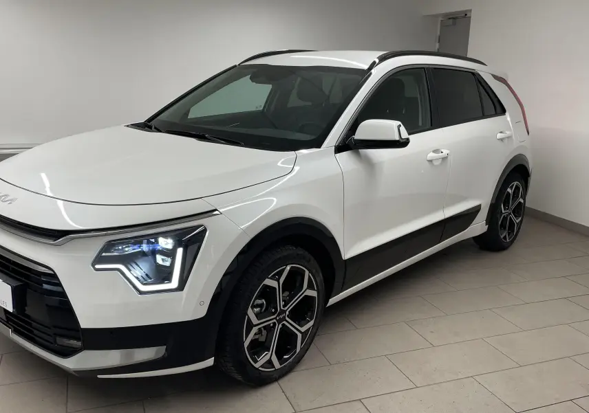 KIA NIRO 2025 blanc vue 3/4 avant droit avec phares LED et jantes alliage distinctives.