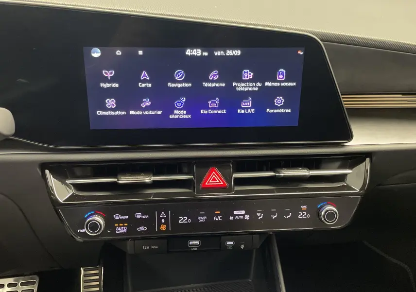 Intérieur du Kia Niro 2025 montrant la console centrale avec écran tactile et commandes de climatisation modernes.