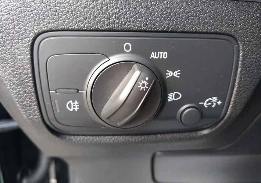 Gros plan sur le sélecteur d'éclairage noir mat du tableau de bord de l'Audi Q2 35 TFSI S-Line 2023.