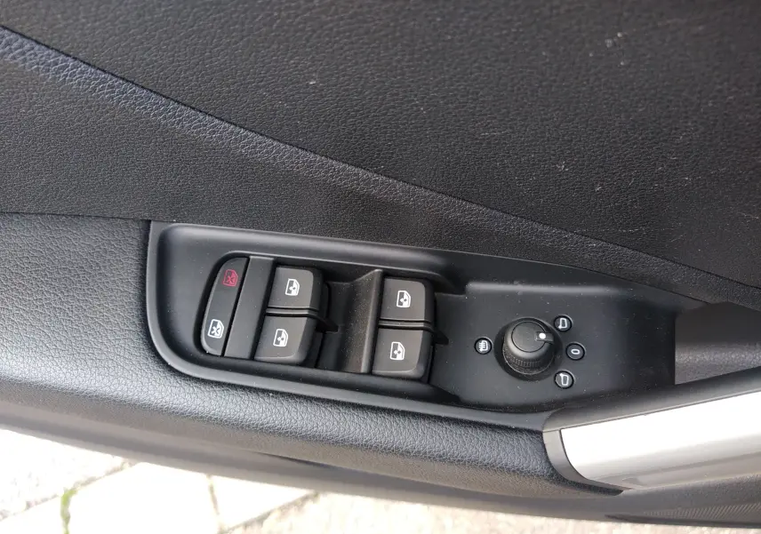 Commandes des vitres électriques et réglage des rétroviseurs sur la porte côté gauche d'un Audi Q2 noir Mito Metal 2023.