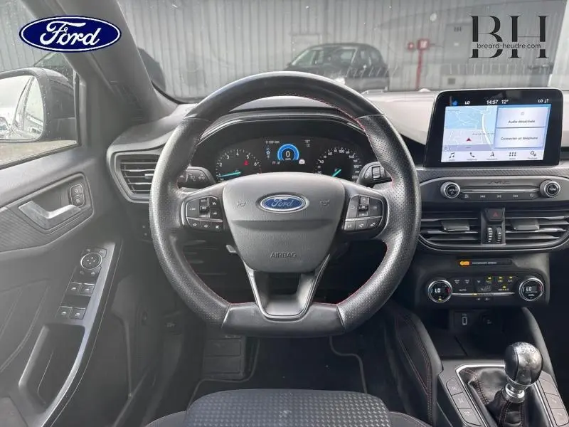 Vue intérieure centrée sur le volant cuir multifonction et tableau de bord numérique d'une Ford Focus noir Shadow 2019.