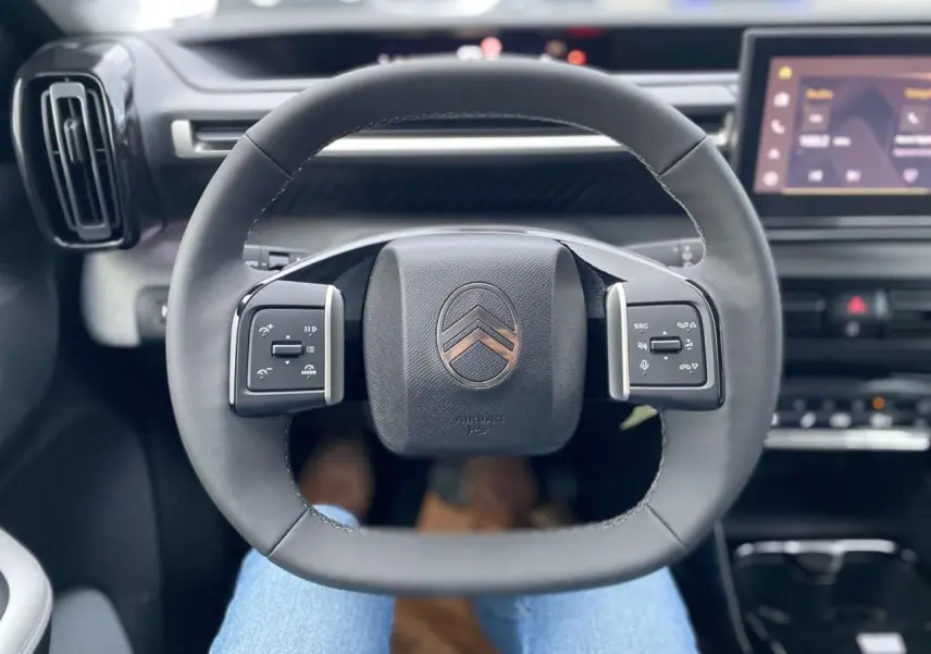 Volant multifonctions Citroën C3 Aircross 2025 vu de face avec tableau de bord et écran tactile en arrière-plan