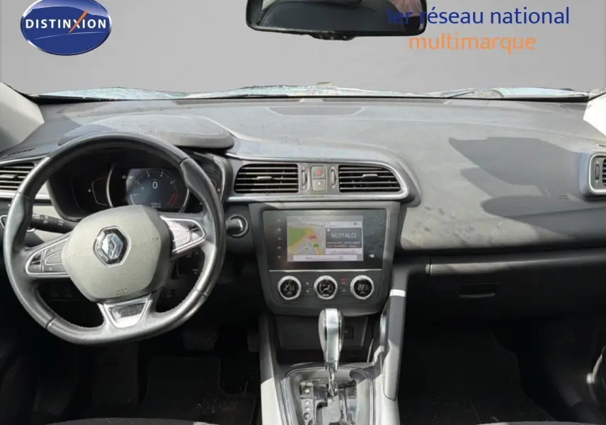 Vue intérieure du tableau de bord du Renault Kadjar gris Highland, montrant le volant, l'écran tactile et la console centrale.