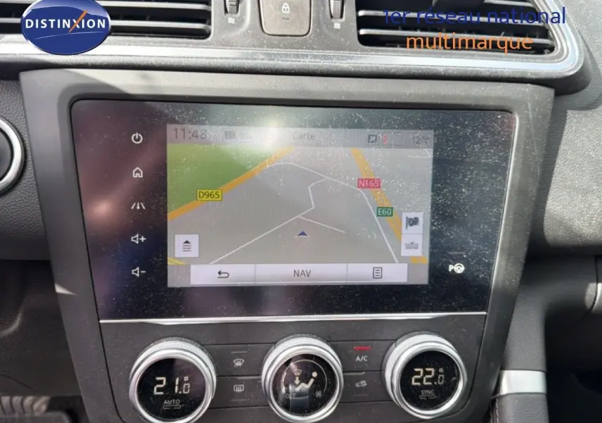 Vue rapprochée de l’écran tactile et des commandes de climatisation du tableau de bord d’un Renault Kadjar gris Highland.