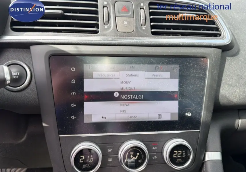 Vue rapprochée de la console centrale du Renault Kadjar gris Highland, avec écran tactile et commandes de climatisation.