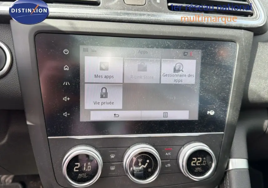 Gros plan sur l’écran tactile et la console centrale du Renault Kadjar gris Highland, affichant la climatisation et les réglages multimédias.