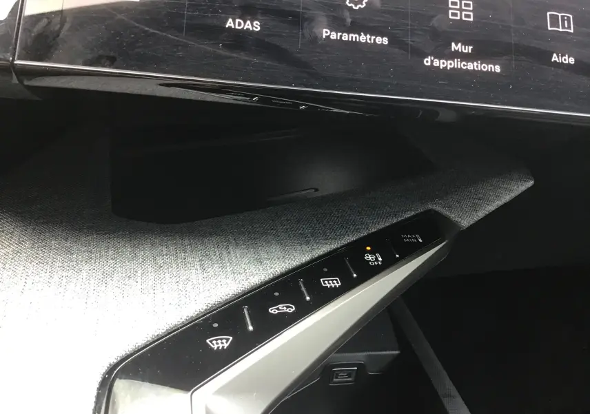 Vue rapprochée du tableau de bord du Peugeot 3008 1.2 Hybrid 145 Allure, montrant les commandes de climatisation sur fond gris Artense.