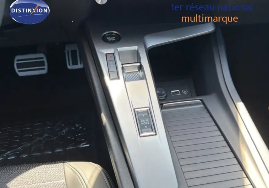 Vue rapprochée de la console centrale de la Peugeot 308 Hybrid 145ch GT, avec levier de vitesses et commandes argentées.