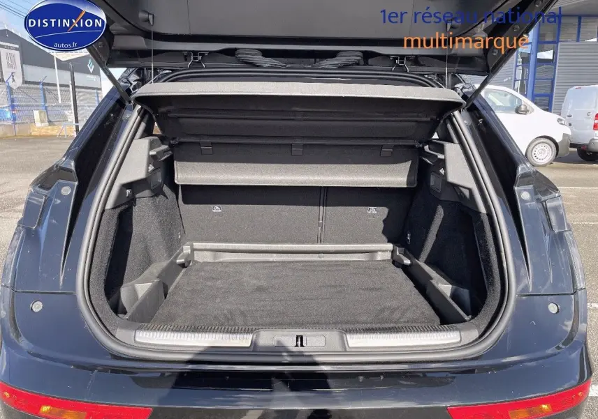 Coffre ouvert d'un DS7 Crossback E-TENSE noir perle métal, vue arrière montrant l'espace de chargement vide.