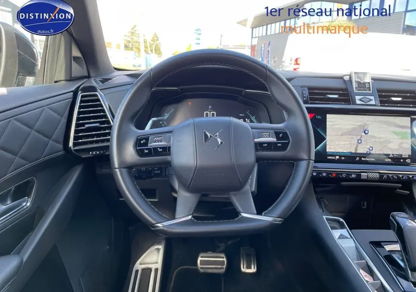 Vue intérieure centrée sur le volant du DS7 Crossback E-TENSE noir perle, avec tableau de bord digital et écran tactile GPS.