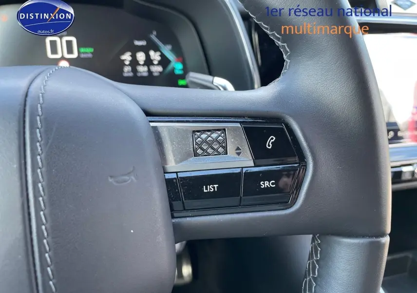 Gros plan sur les commandes gauche du volant en cuir noir du DS7 Crossback E-TENSE 2021, affichage numérique en arrière-plan.