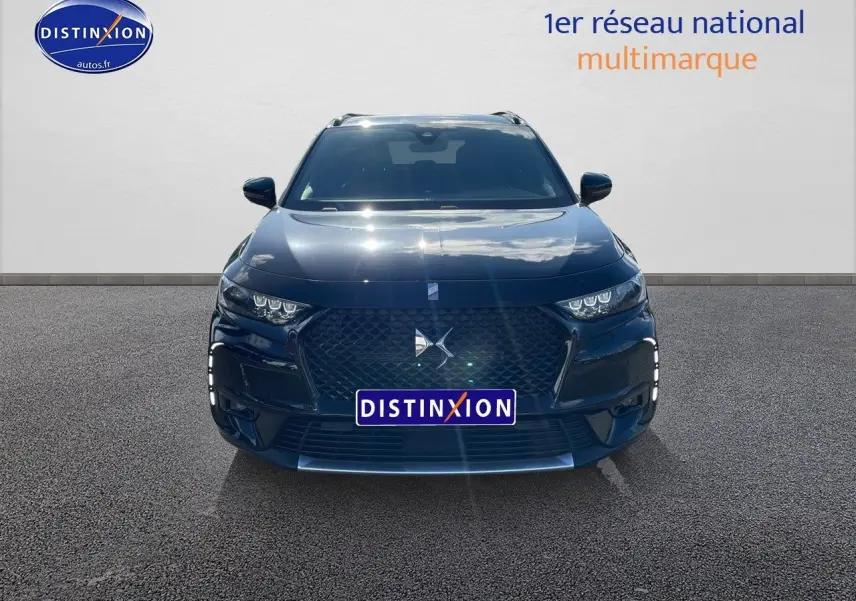 Vue frontale d'un DS7 Crossback E-TENSE noir perle métal avec calandre distinctive et phares LED allumés.
