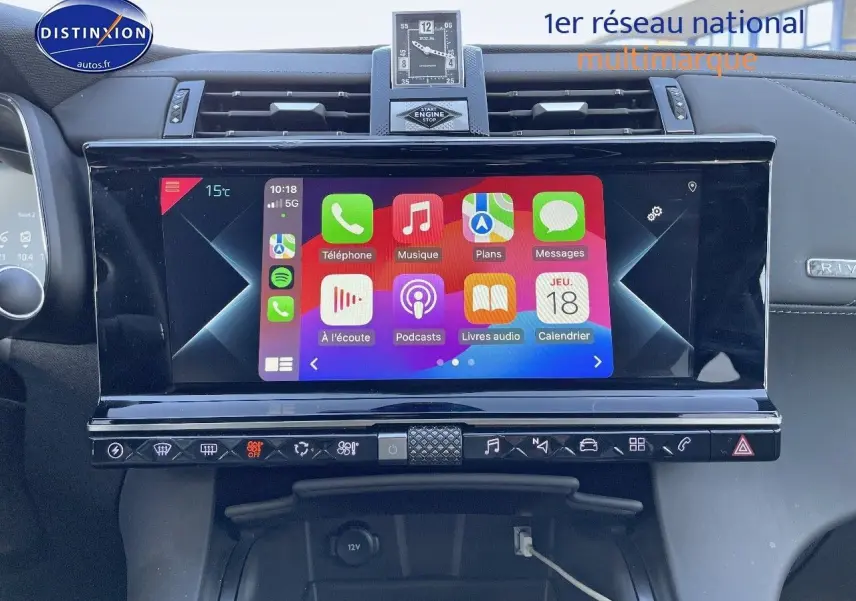Écran tactile central du DS7 Crossback noir perle, affichant les applications Apple CarPlay, avec horloge analogique au-dessus.