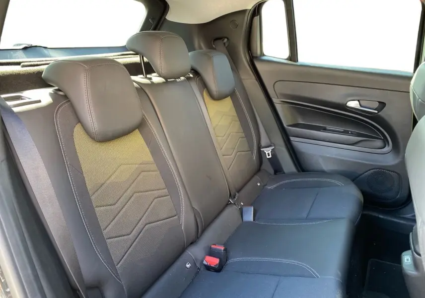 Vue intérieure côté droit des sièges arrière noirs du Jeep Avenger électrique 2023 avec ceinture et porte.