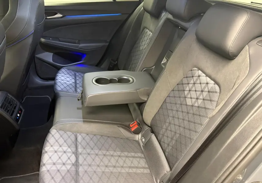 Vue intérieure côté droit des sièges arrière gris avec accoudoir central et porte-gobelets sur Volkswagen Golf 2025 R-Line Edition.
