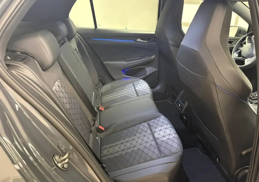 Vue intérieure côté gauche montrant les sièges arrière en tissu gris et cuir noir de la Volkswagen Golf 2025 R-Line Edition.